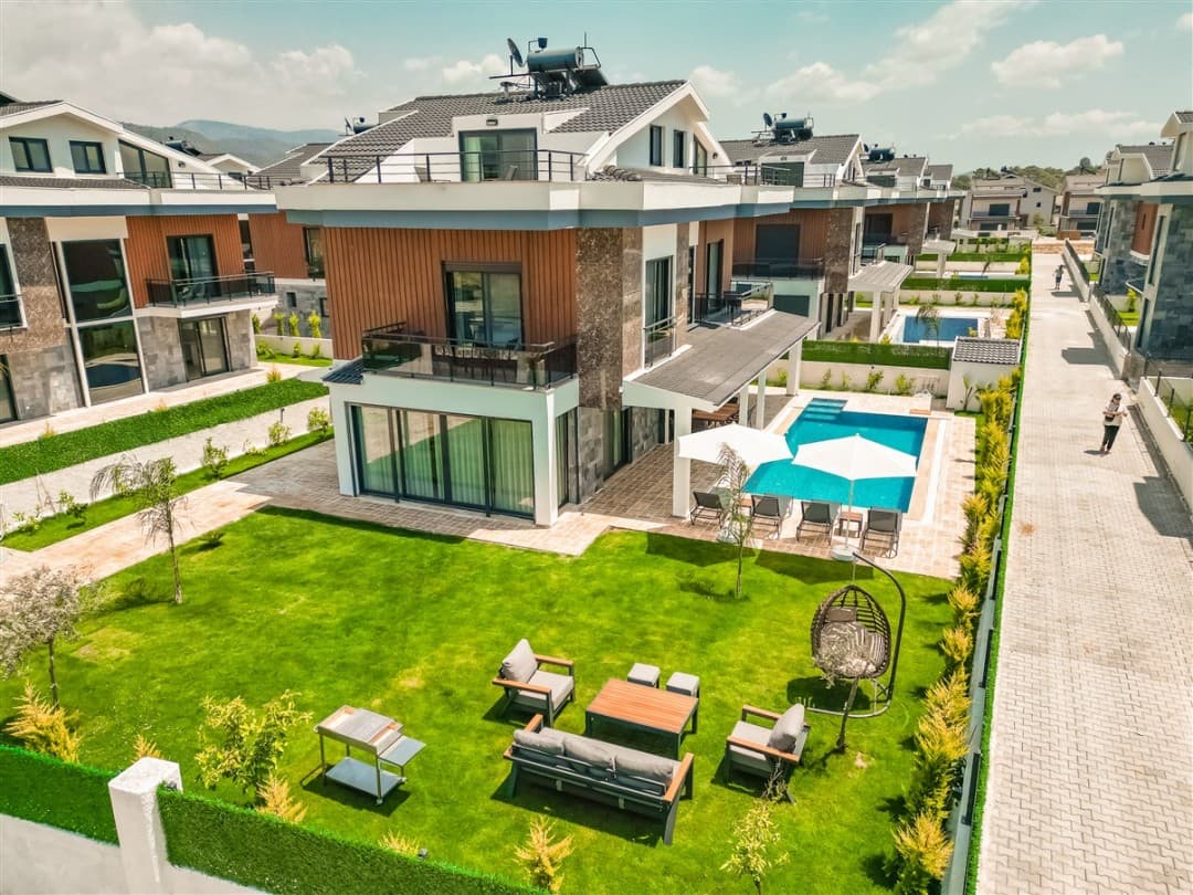 Bahçesinde oturma grubu, salıncak ve özel havuzu bulunan modern mimarili müstakil villa.