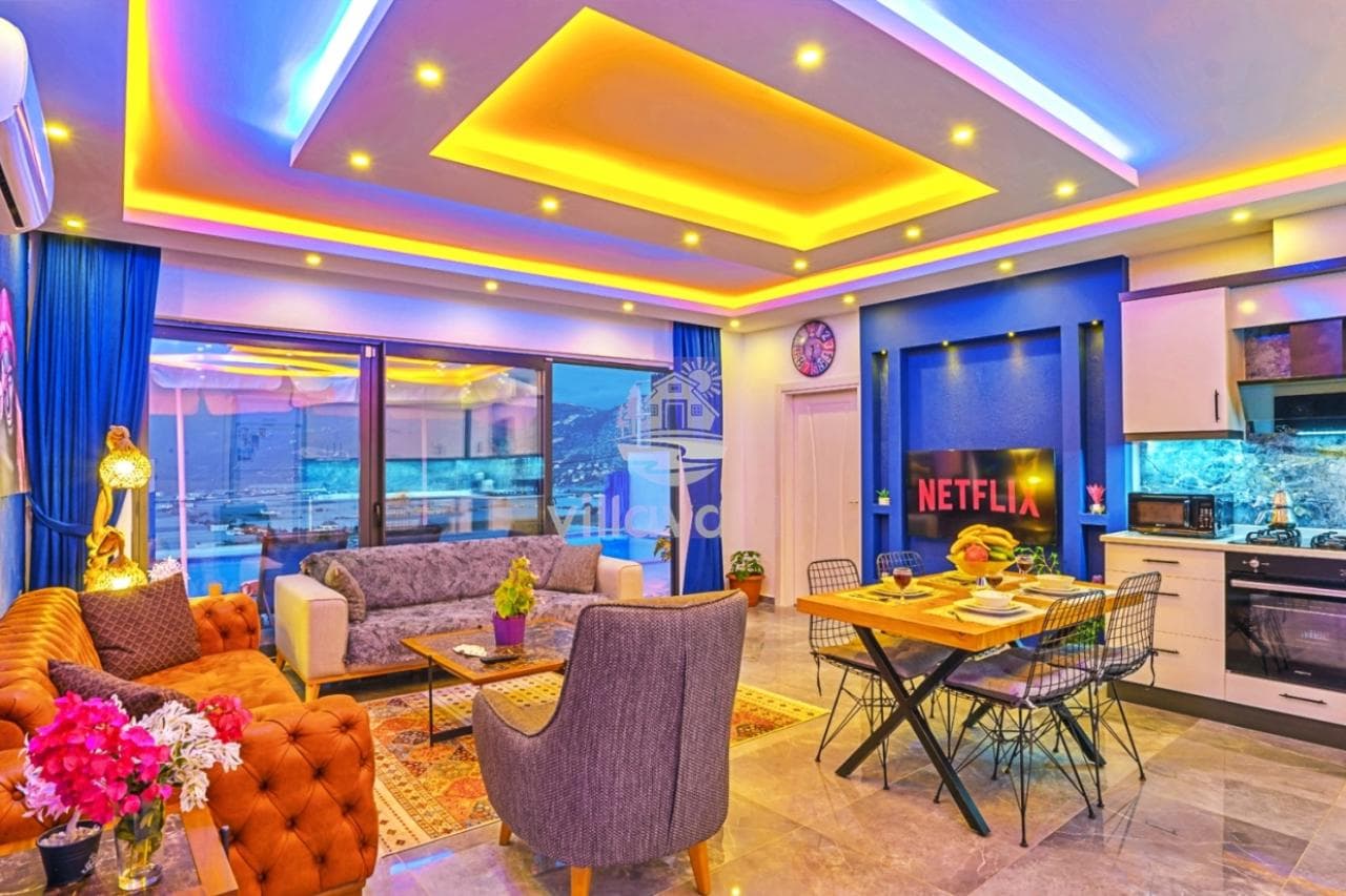 Renkli tavan aydınlatmalı salon, yemek masası ve oturma grubu.