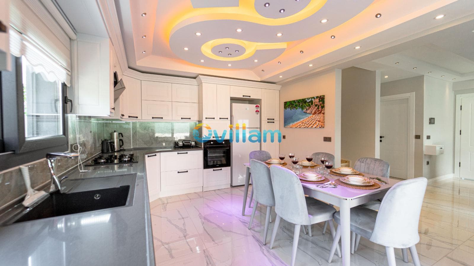 Beyaz mutfak dolapları ve modern yemek masası takımı.