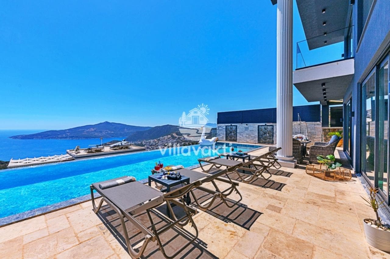 Deniz manzaralı sonsuzluk havuzu, şezlonglar ve modern mimariye sahip villa terası.